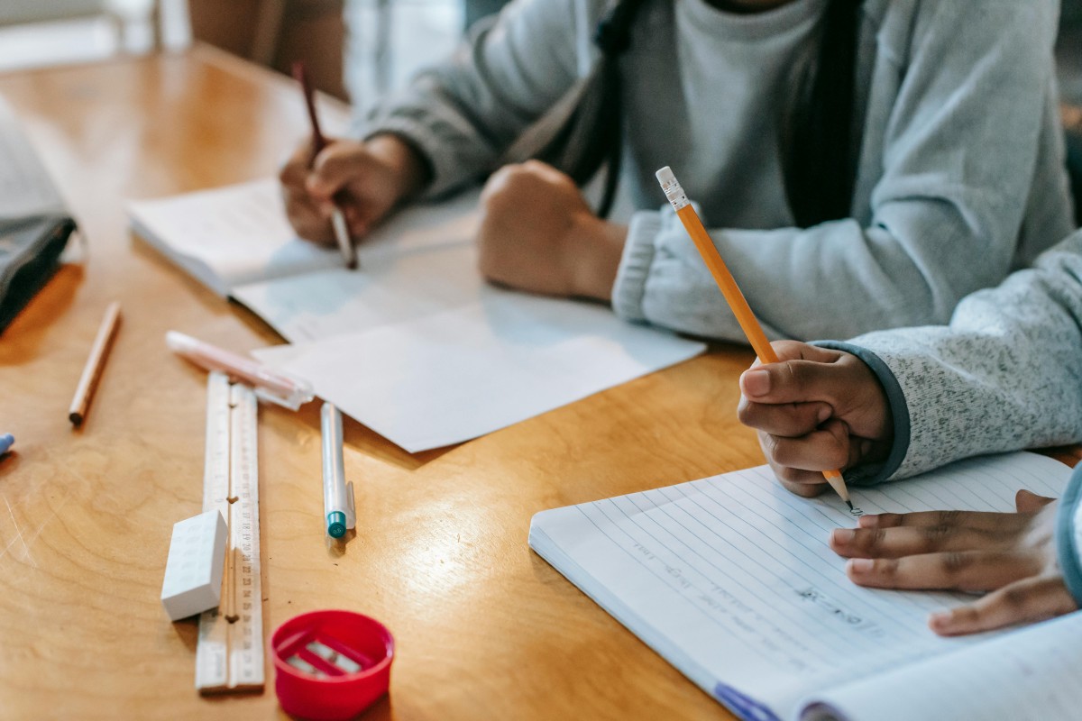 Crop pupils writing in copybook on desk by katerina holmes via pexels